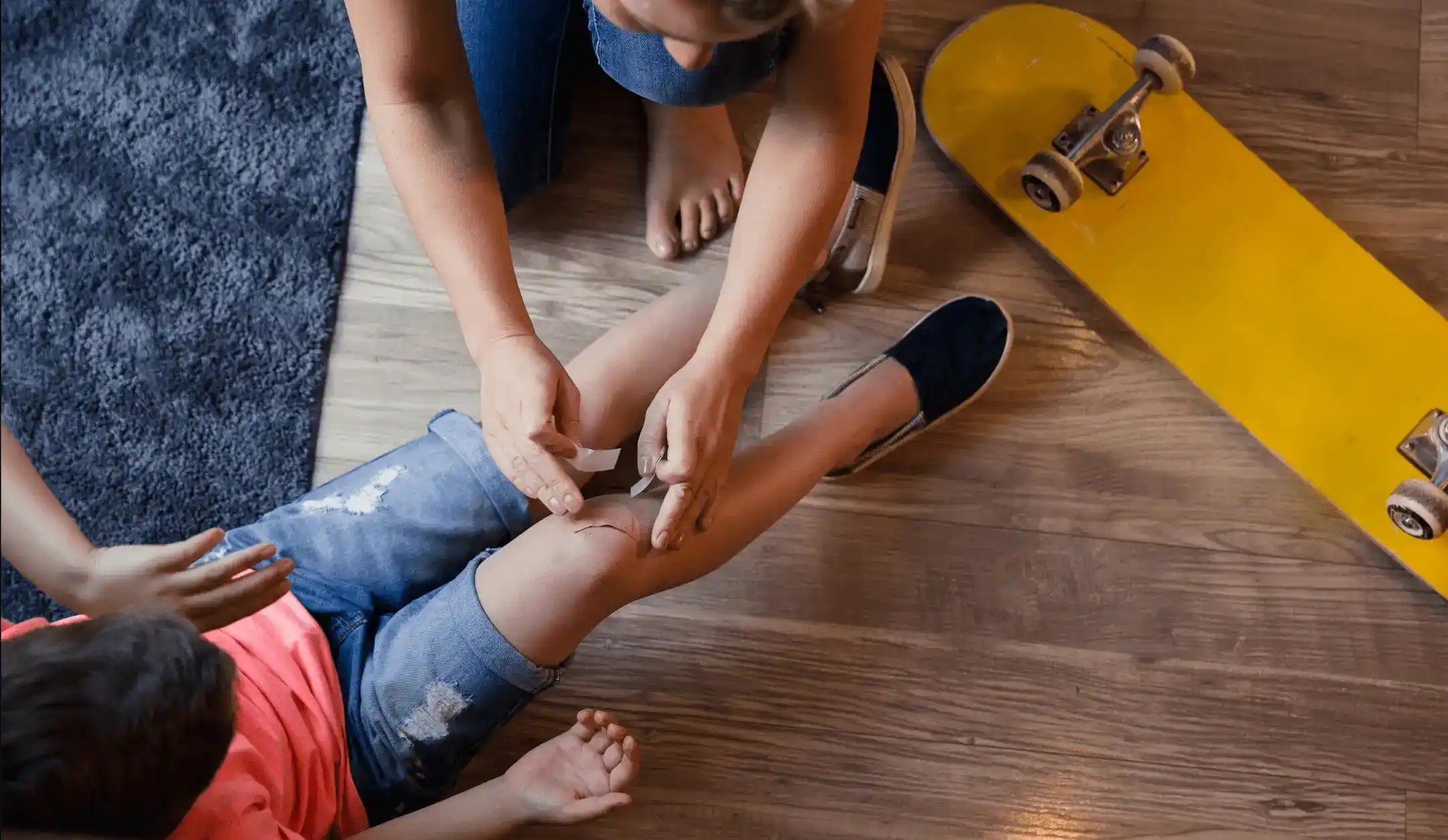 Woman putting a band aid on a child's knee